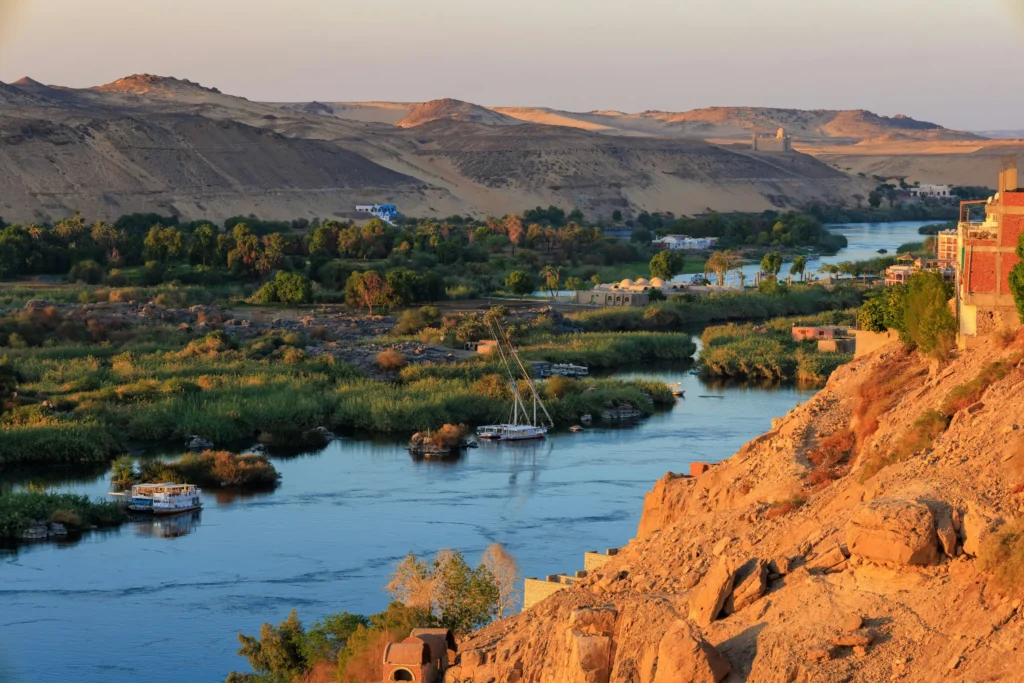 Vallée du Nil à Assouan au coucher du soleil avec felouques amarrées entre les îlots